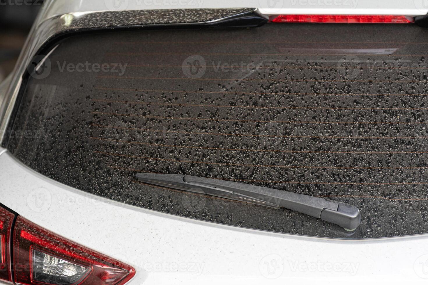 Rear window hatchback dirty car rear view on a dusty glass. Dirty and dusty rear window of a white car. photo