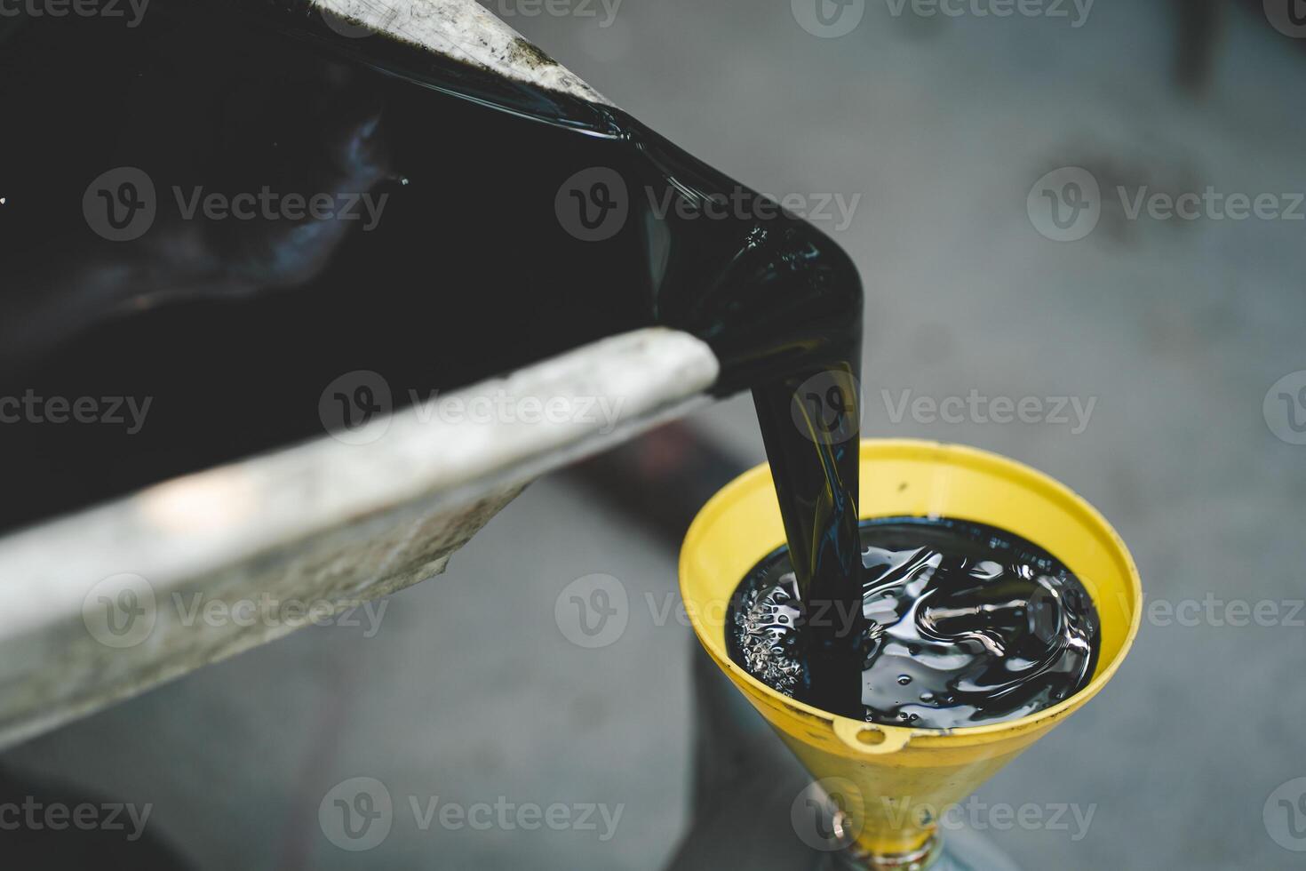 Old engine oil. Pouring old black oil of car engine from oil pan into bottle on top view lubrication used for recycle. photo