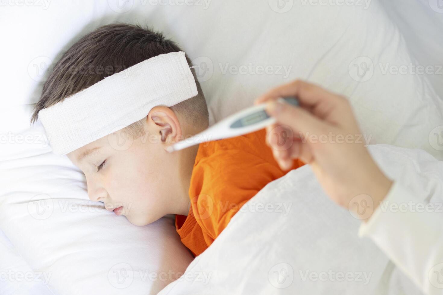 A mother measures the temperature of her sick child photo