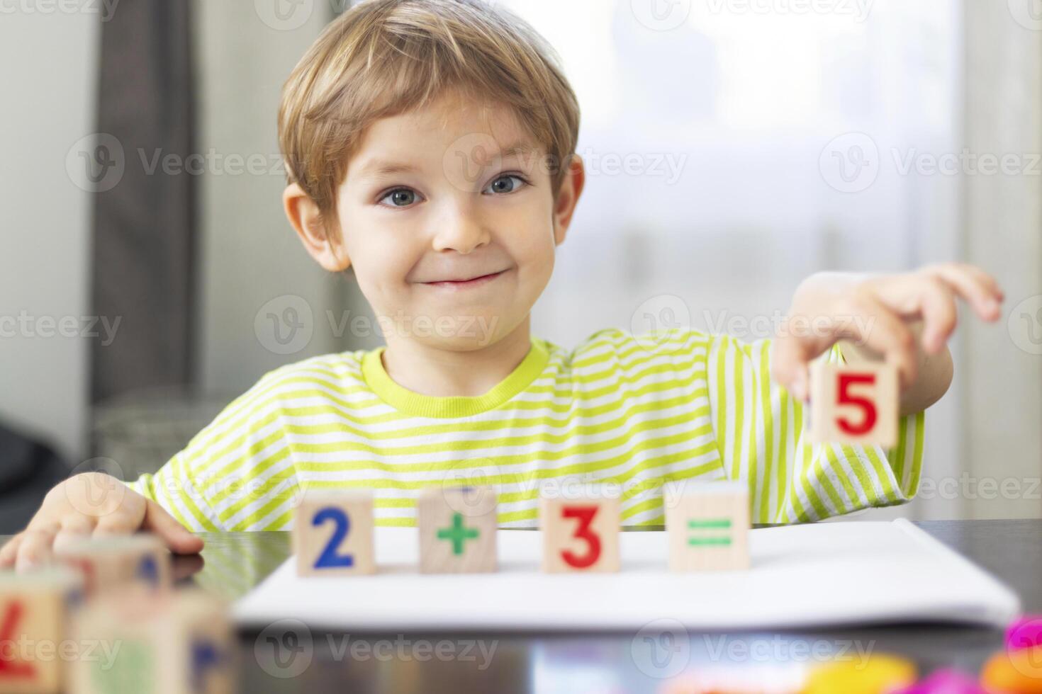 Smiling child learning math with blocks photo