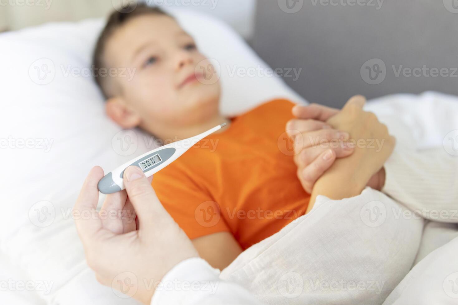 A mother measures the temperature of her sick child. photo
