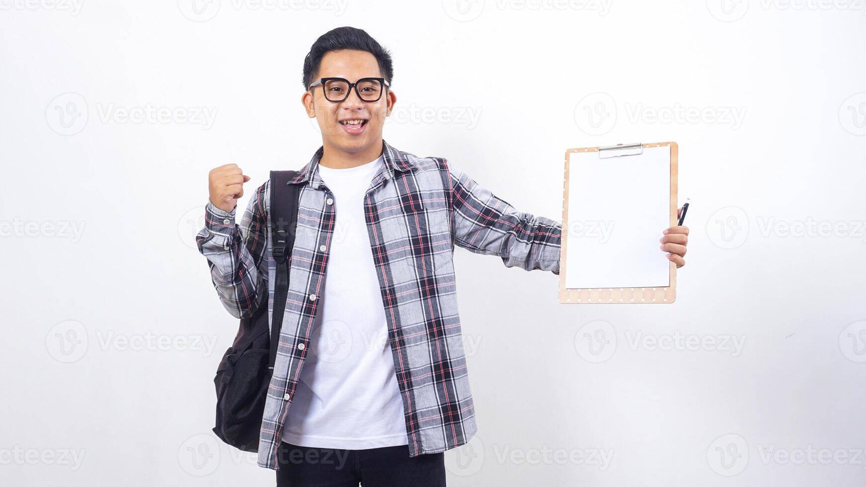 Smart young Asian male college student with a backpack holding clipboard with blank paper mock up isolated on white background photo