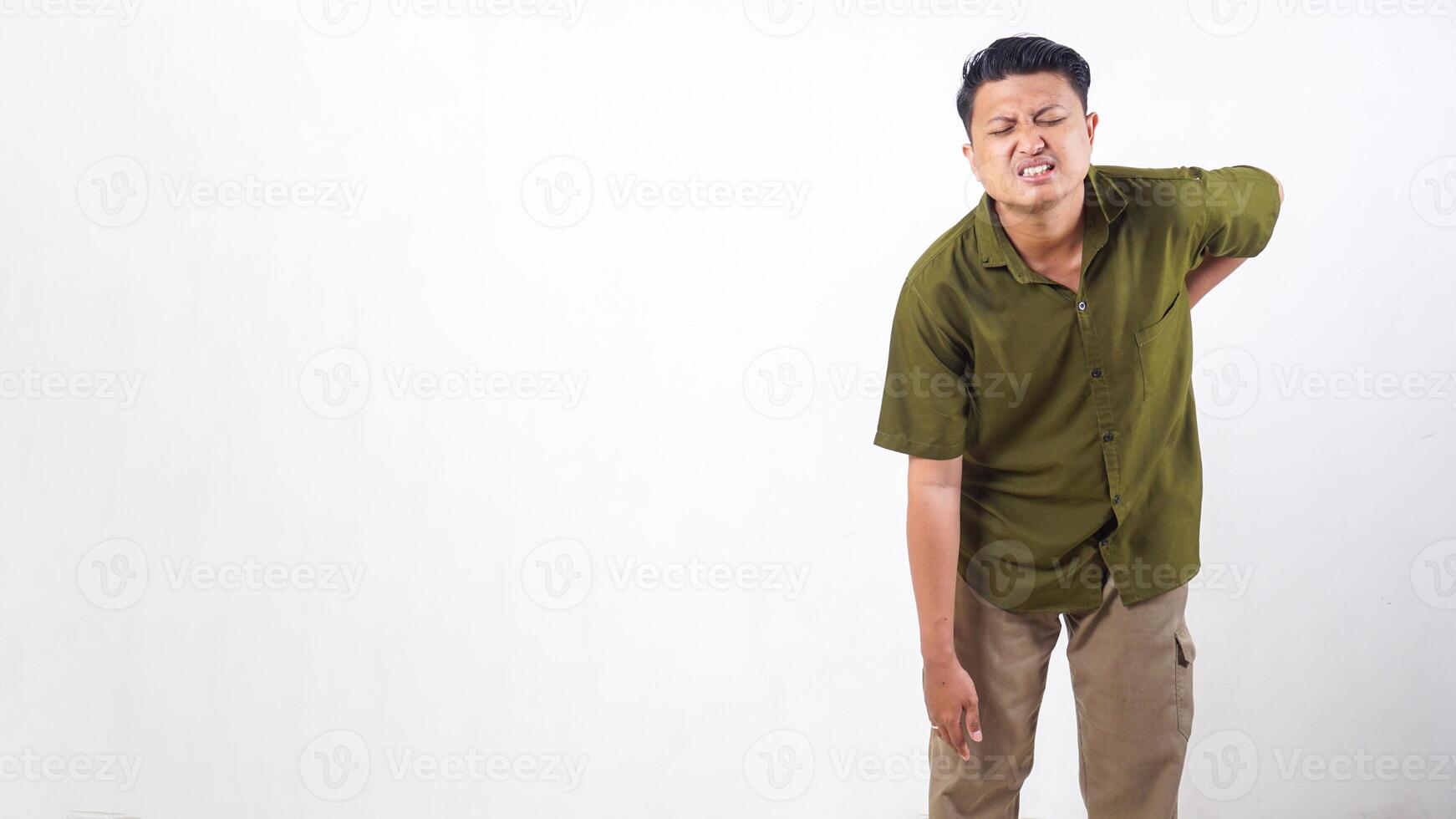 Asian man clutching his back in pain due to muscle strain isolated on white background photo