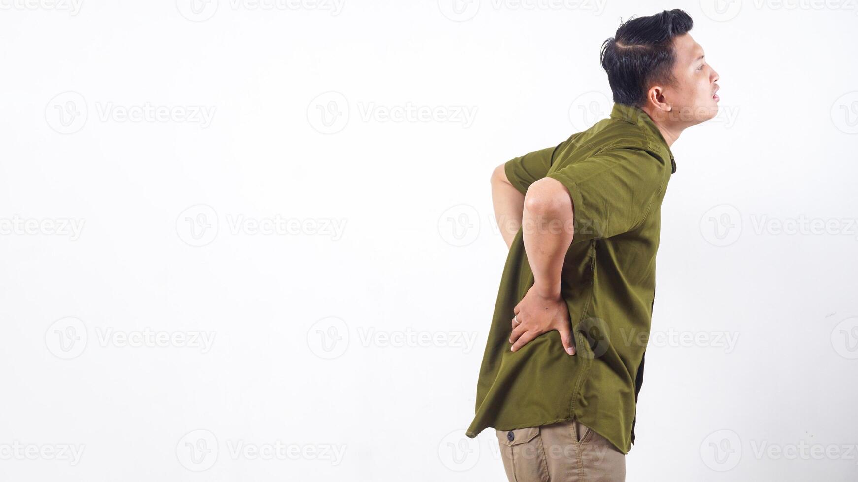 Asian man suffering from back pain, holding his lower back isolated on white background photo