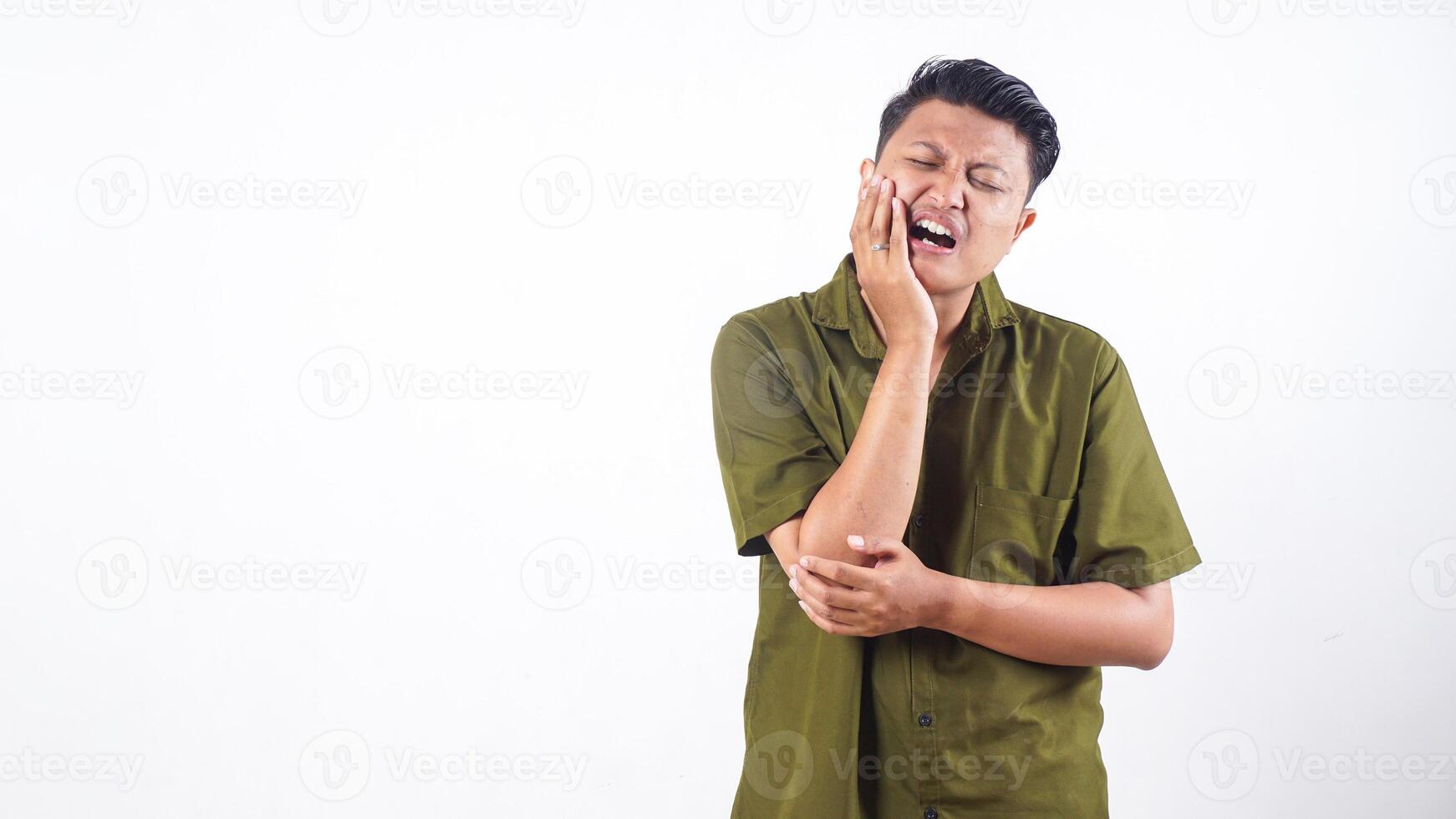 Unwell Asian man touch his jaw due to toothache isolated on white background photo