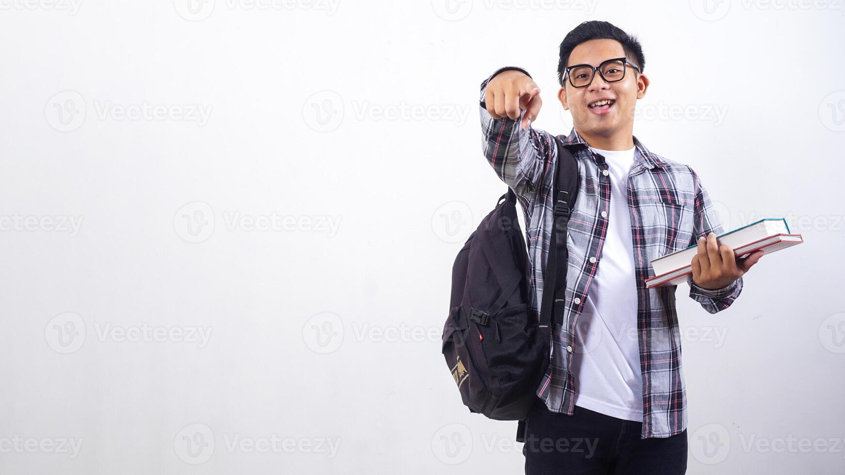 Young Asian male college student with a backpack holding school books standing isolated on white background photo