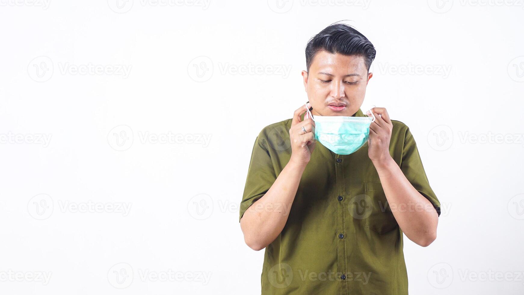 Sick man with facial mask bending over from cough isolated on white background photo