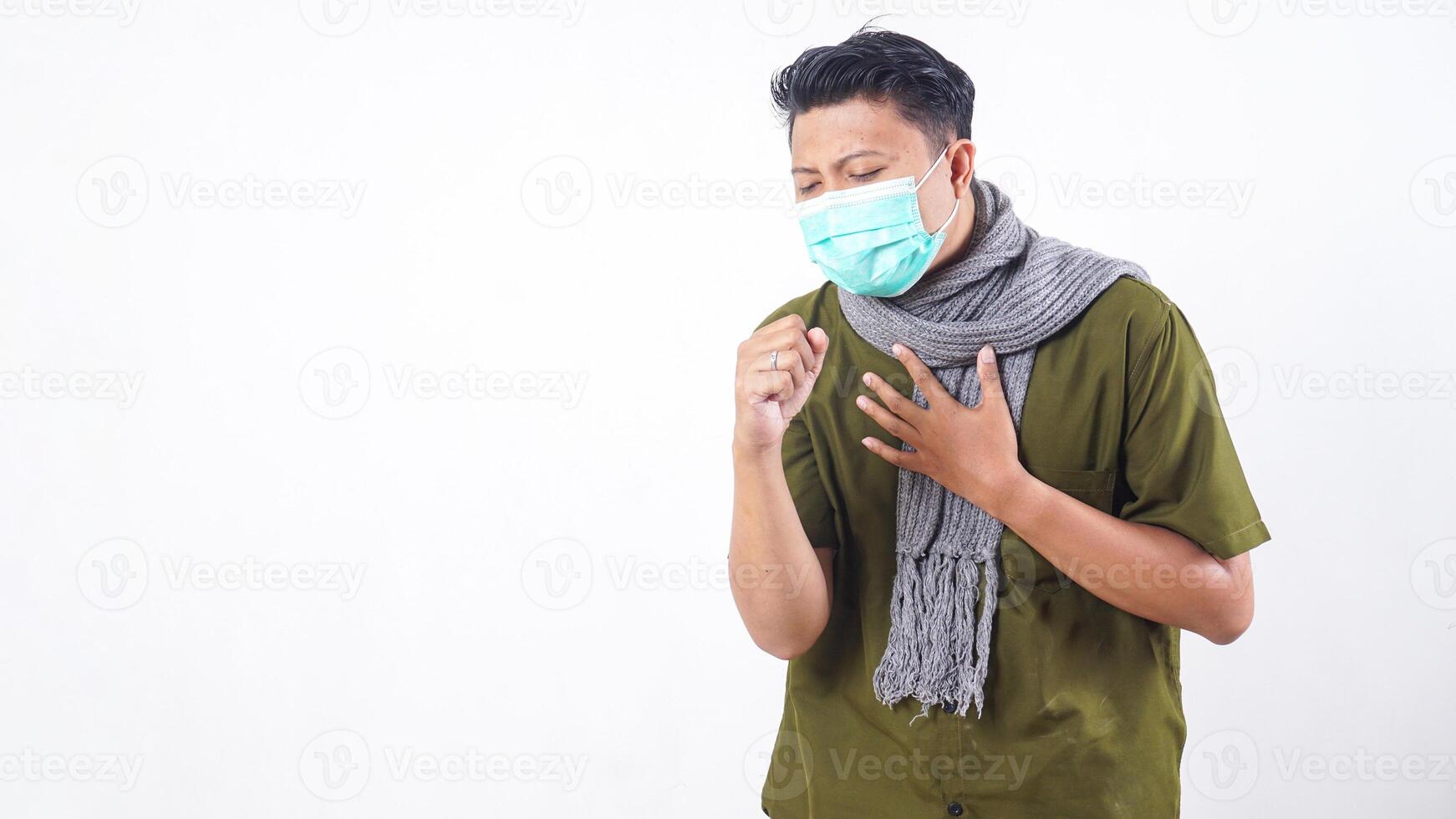Sick man wearing mask and wool scarf coughs painfully isolated on white background photo