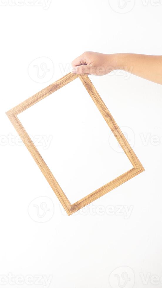 Hand holding blank wooden photo frame isolated on white background