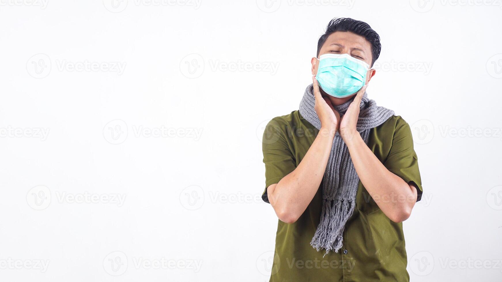Sick adult man with mask touching his jaw because of toothache isolated on white background photo