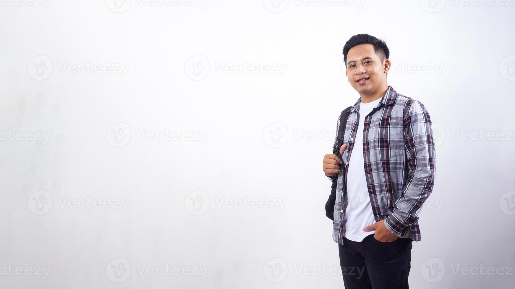 Young Asian male college student with a backpack isolated on white background photo