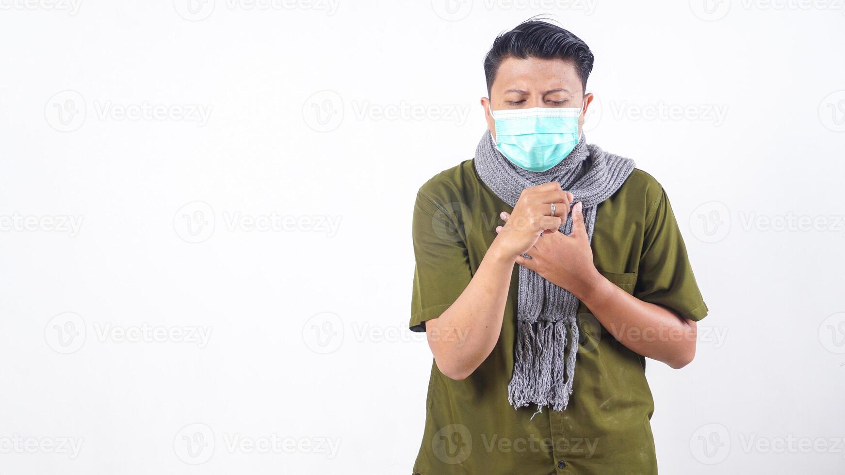 Sick man with mask and wool scarf coughs painfully isolated on white background photo