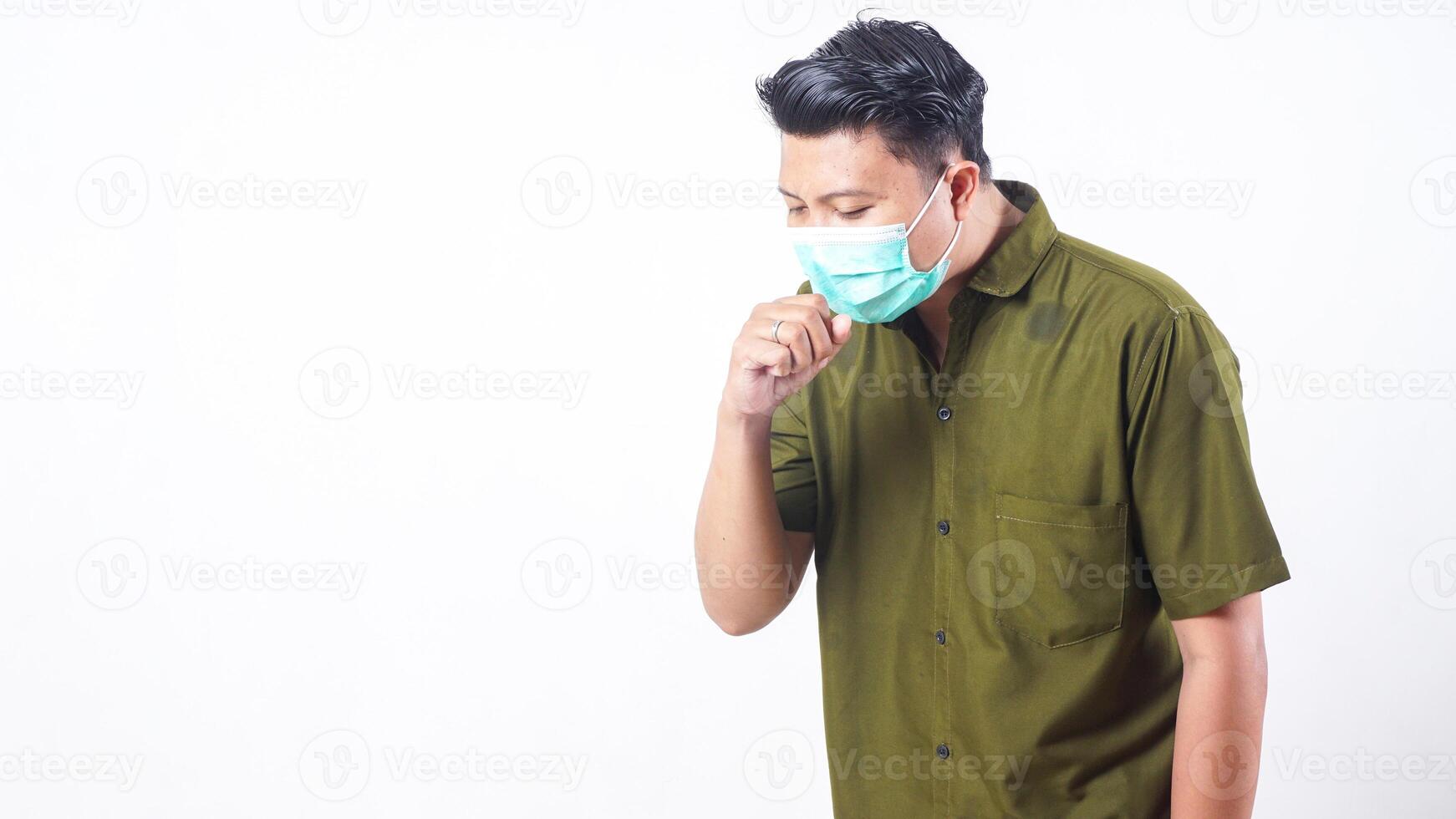 Sick adult man wearing a protective mask is coughing isolated on white background photo