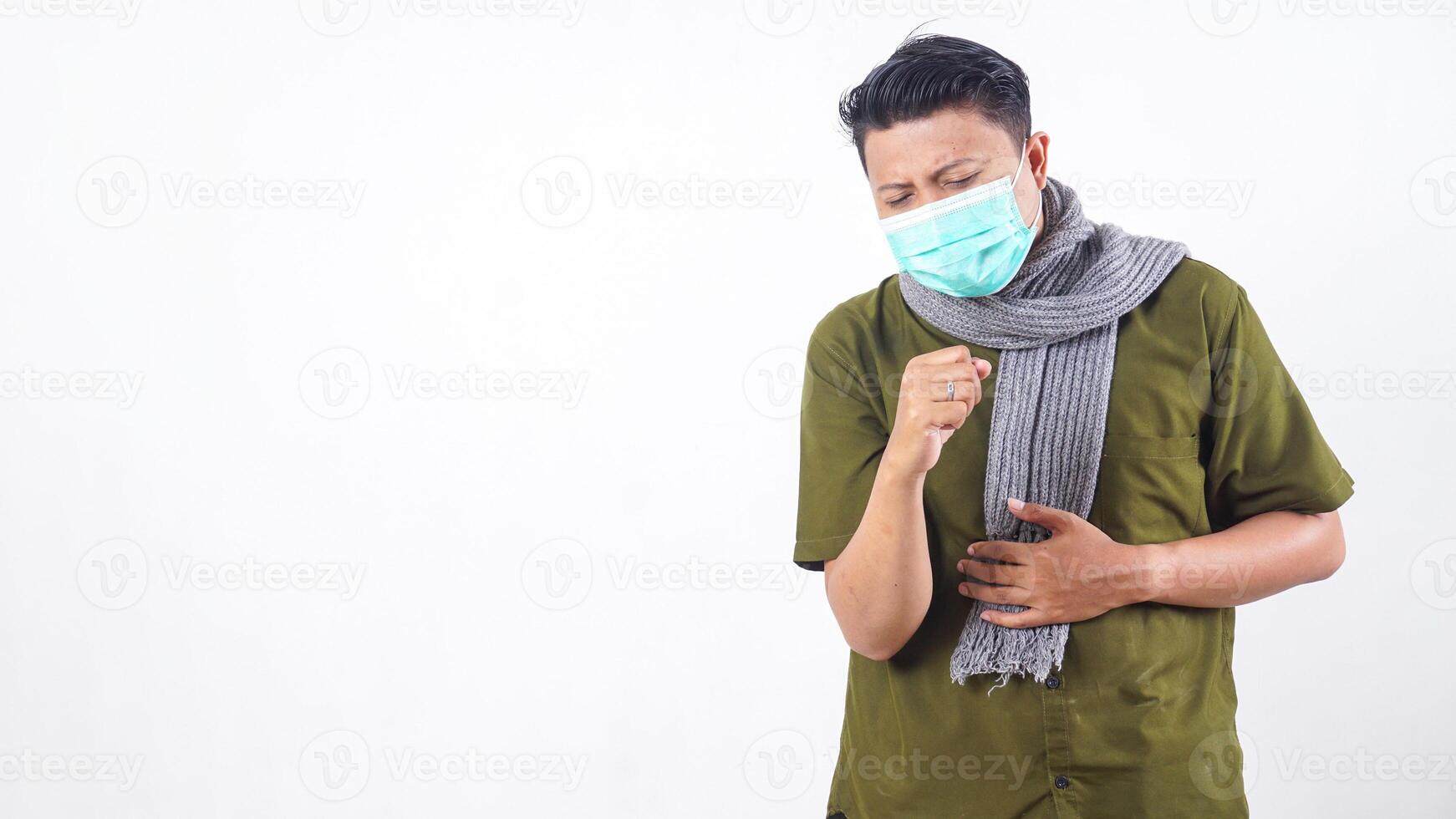 Man in protective mask and wearing wool scarf struggling with cough isolated on white background photo