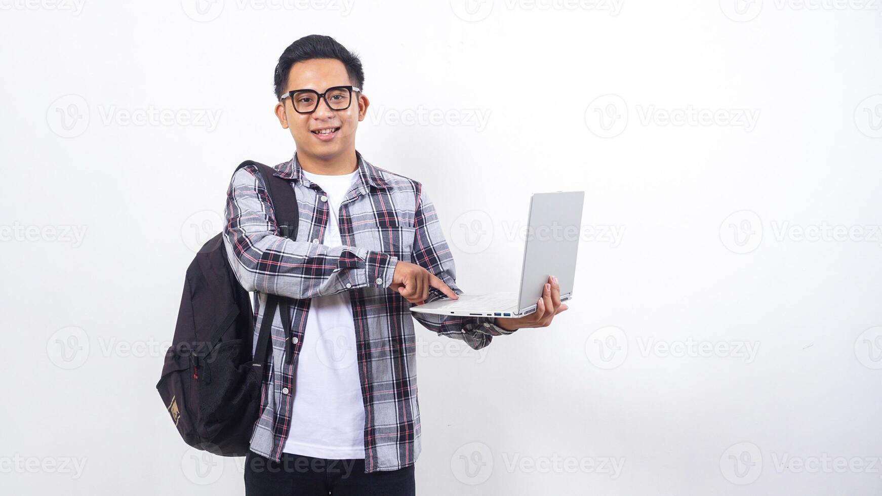 Portrait of happy young Asian male college student with a backpack and touching open laptop notebook isolated on white background photo