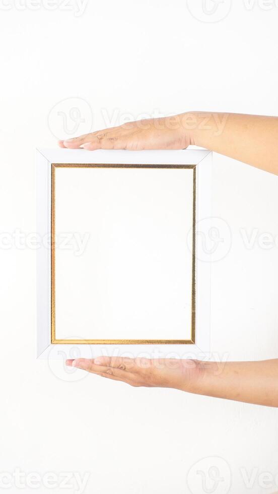 Hand holding white colored wood picture frame isolated on white background photo