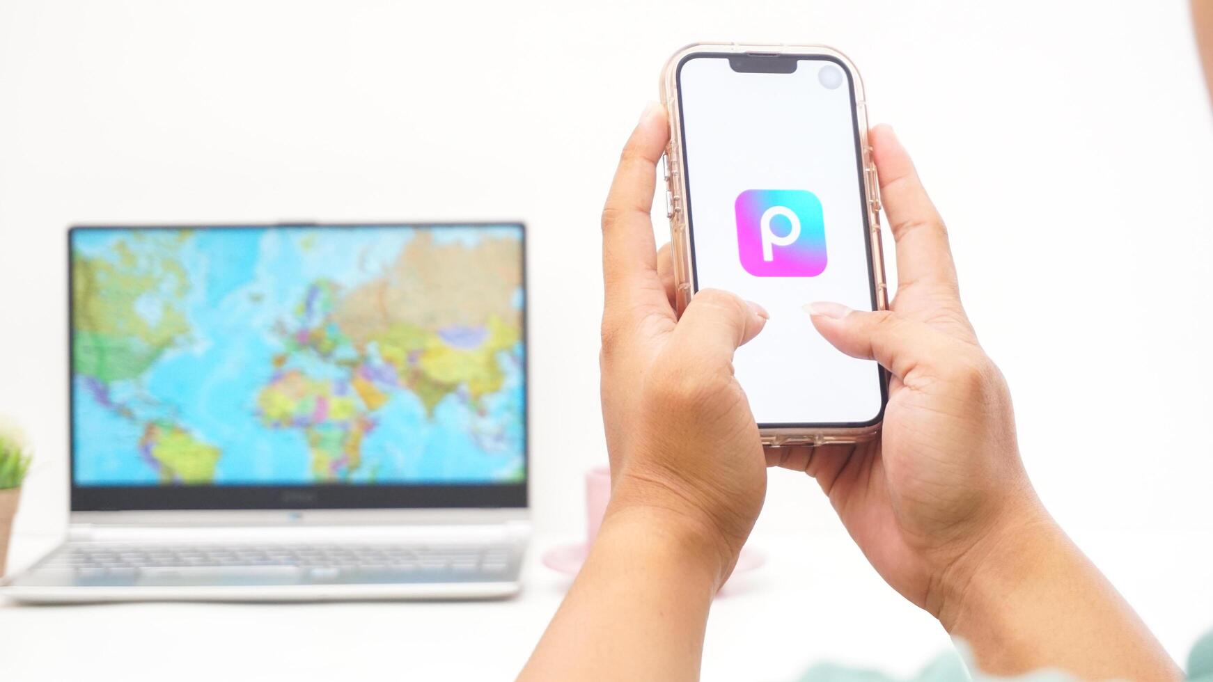 Yogyakarta, Indonesia, 2025 - Man holds smartphone showing Picsart, creative editing platform application on the screen isolated on white background photo