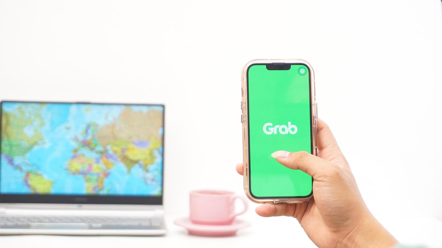 Yogyakarta, Indonesia, 2025 - Man holding smartphone with Grab, on-demand service platforms in Indonesia application on the screen isolated on white background photo
