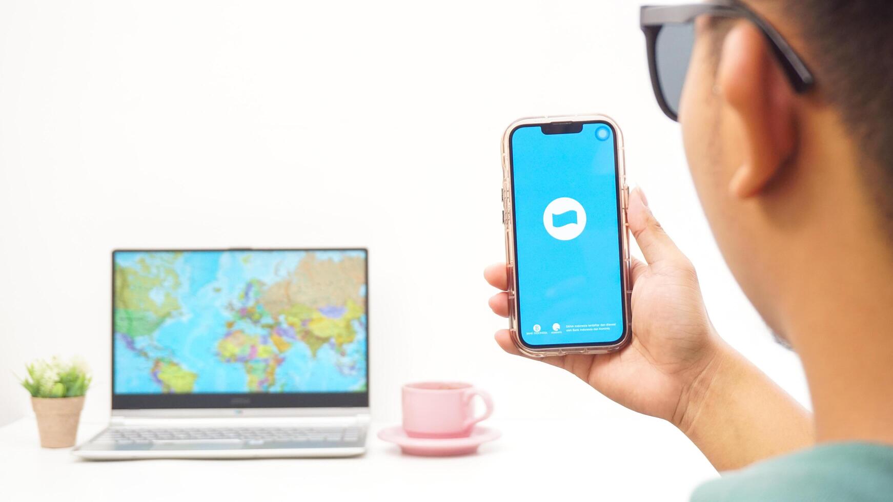 Yogyakarta, Indonesia, 2025 - Man holds smartphone with DANA, digital wallet in Indonesia application is loaded on the screen isolated on white background photo