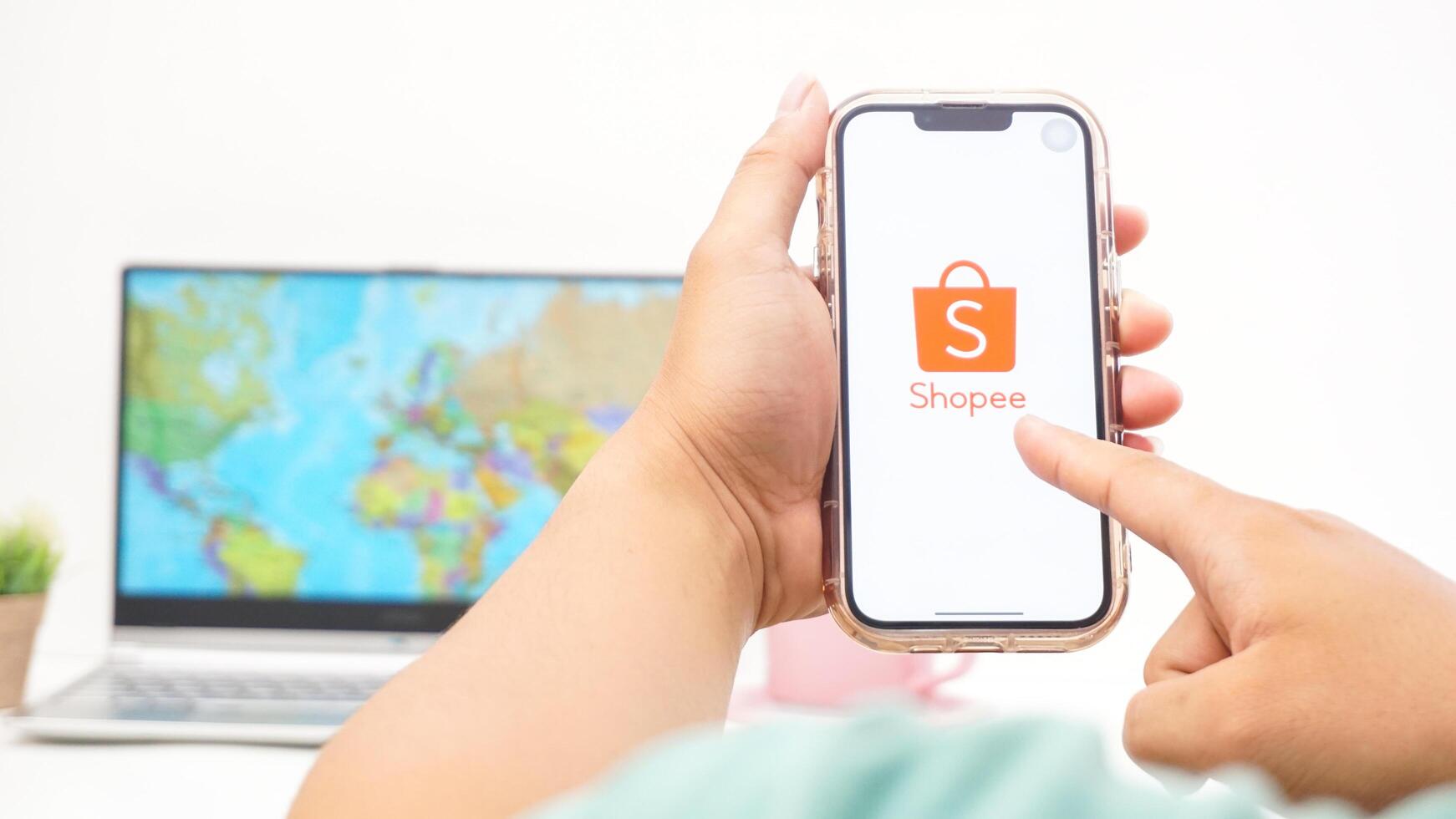 Yogyakarta, Indonesia, 2025 - Man holding smartphone with Shopee, electronic commerce or online shopping platform application is loaded on the screen isolated on white background photo
