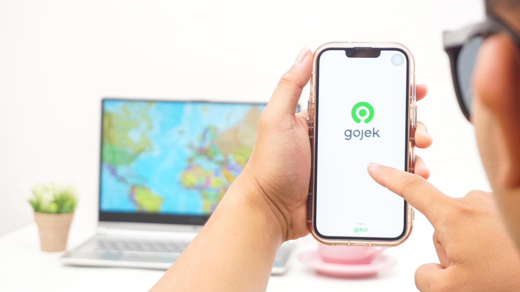 Yogyakarta, Indonesia, 2025 - Man holding smartphone with Gojek, on-demand service platforms in Indonesia application on the screen isolated on white background photo