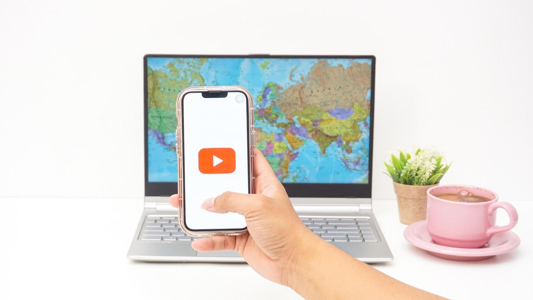 Yogyakarta, Indonesia, 2025 - Man holding smartphone with Youtube platform application on the screen isolated on white background photo