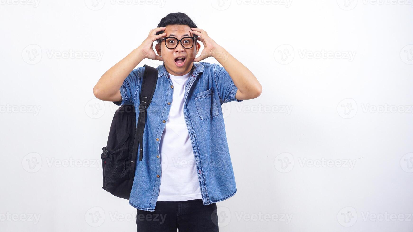 Stressed young Asian male university student in casual outfit with backpack isolated on white background photo