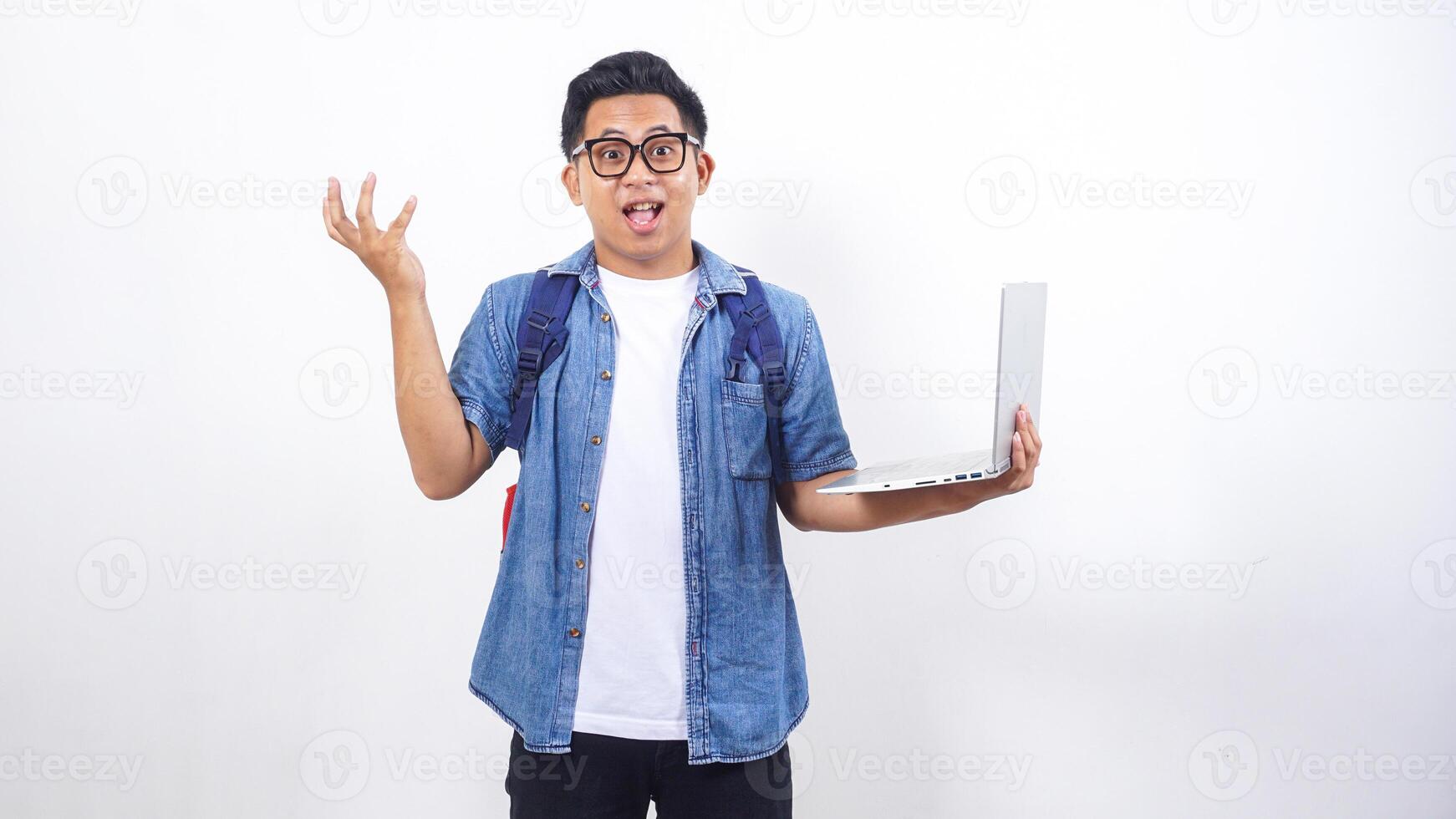 Smart young Asian male university student in casual outfit with backpack and holding open laptop isolated on white background with copy space photo