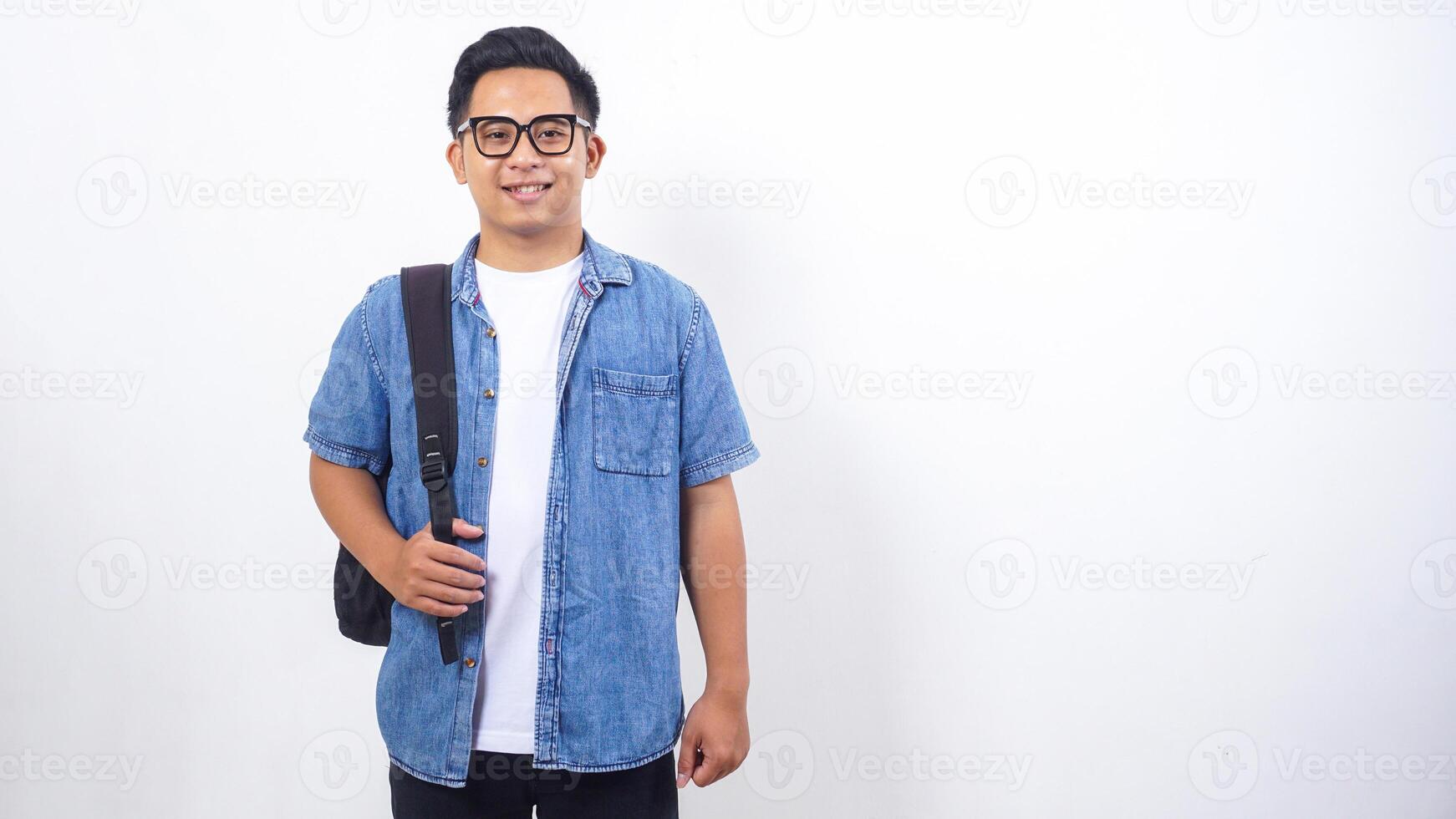 Young Asian male university student in casual outfit with backpack isolated on white background photo