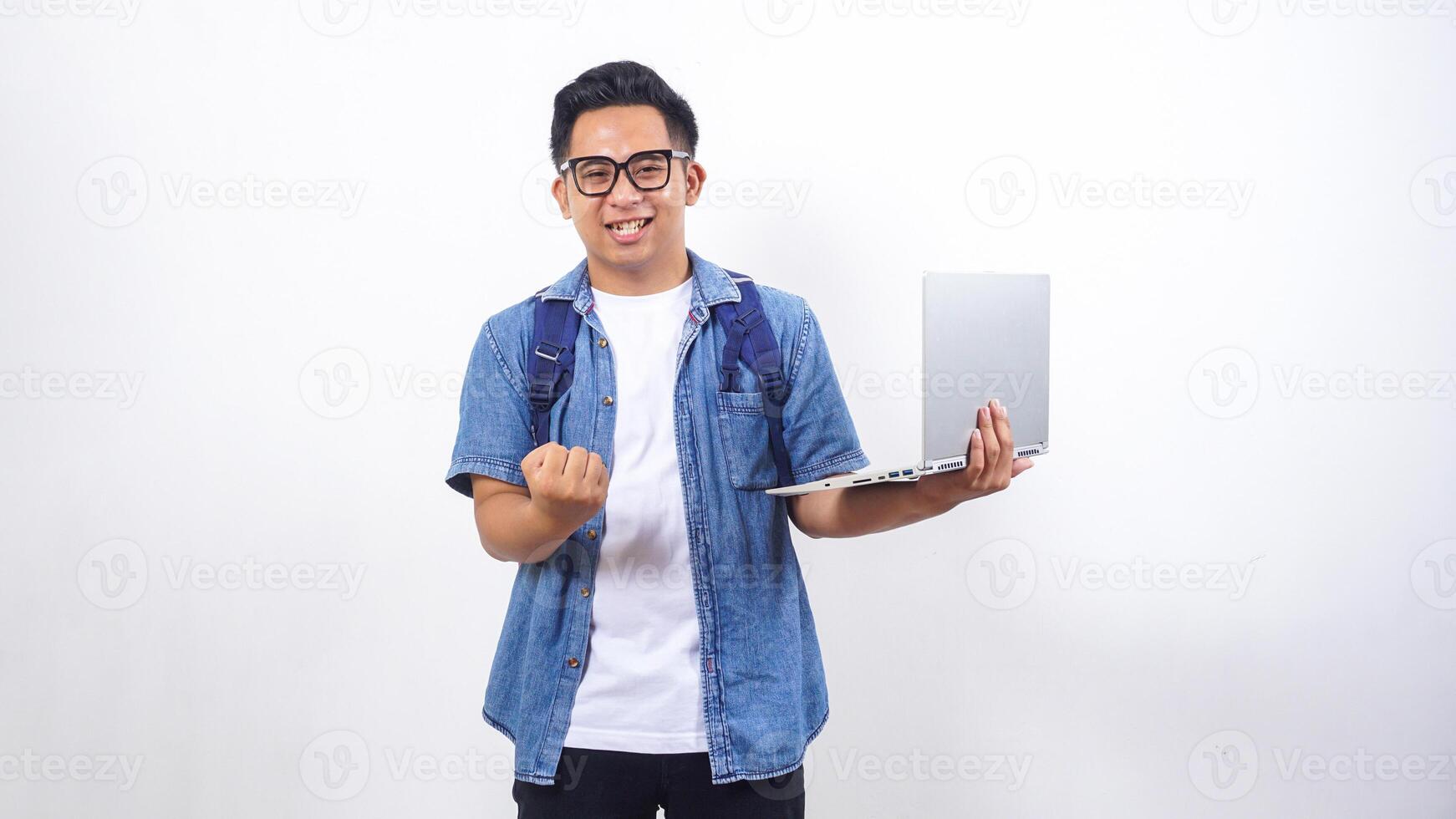 Handsome young Asian male university student in casual outfit with backpack and holding open laptop isolated on white background with copy space photo