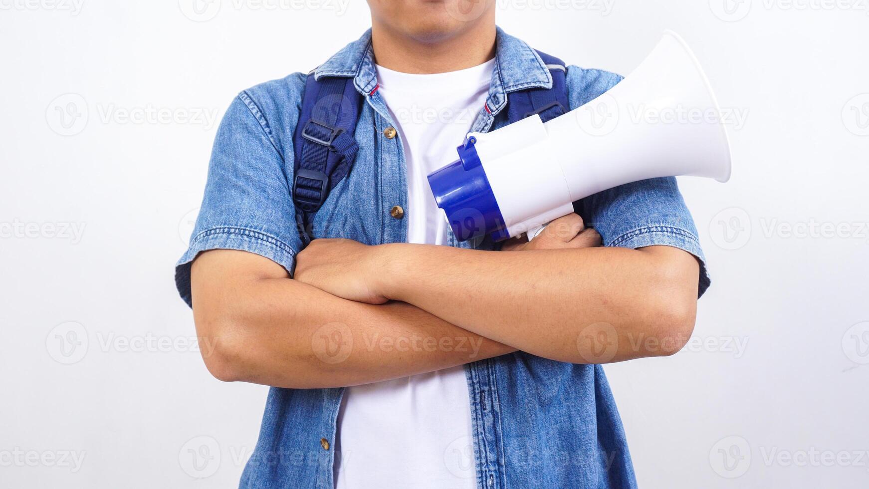 Close up of a young male university student in casual outfit with backpack is holding megaphone isolated on white background photo
