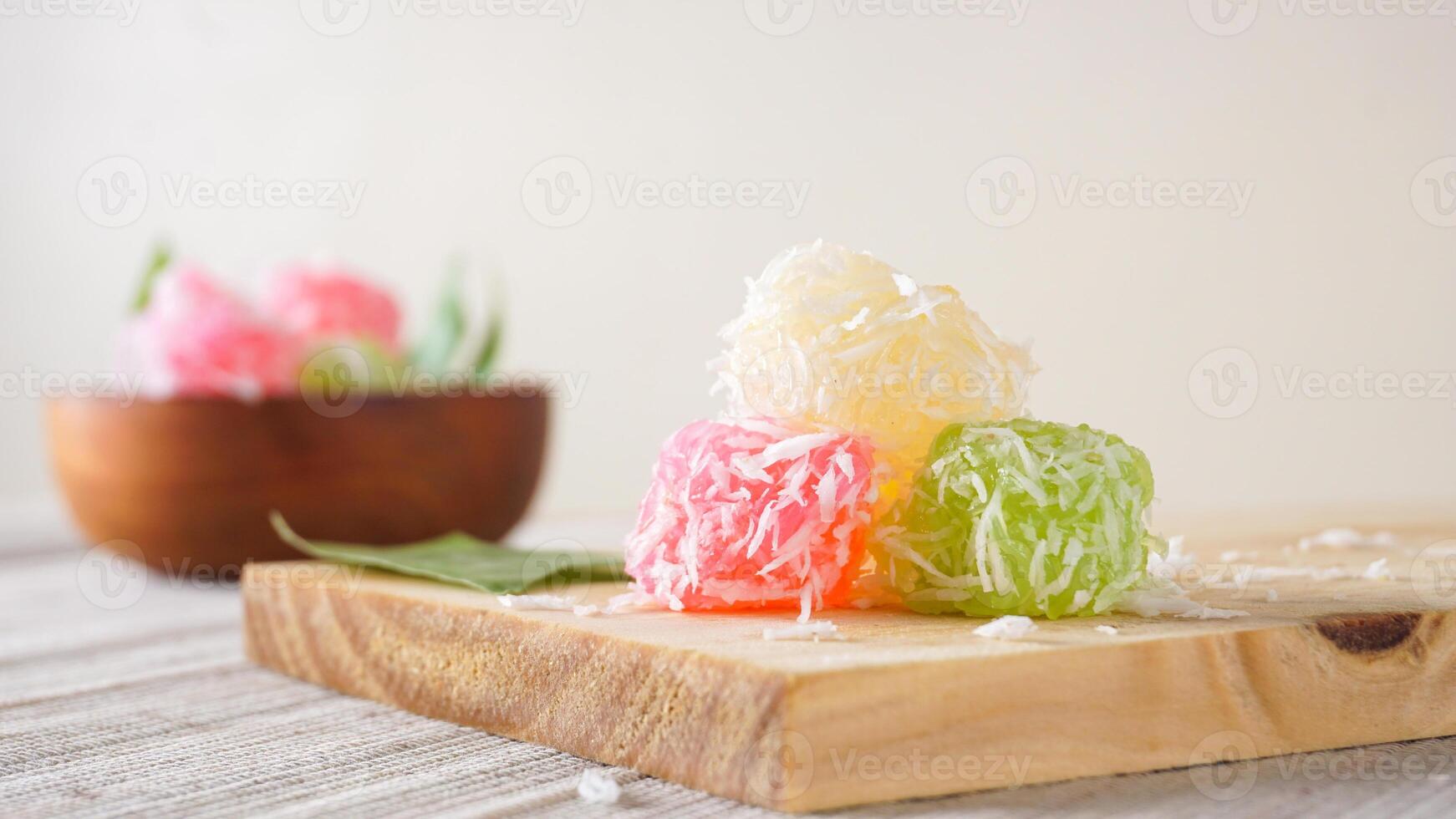 Cenil, a traditional Indonesian snack food on wooden platter isolated on white background photo