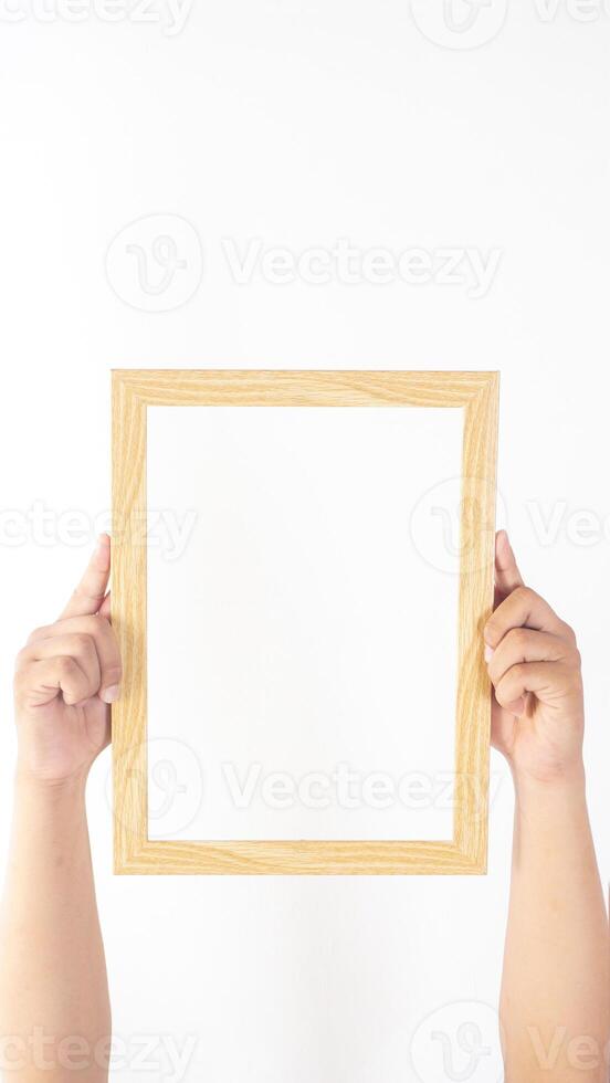 Hand holding empty wood photo frame isolated on white background