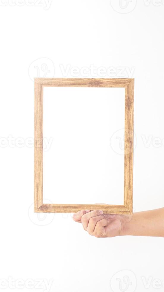 Hand holding empty wooden photo frame isolated on white background