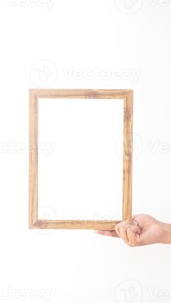 Hand holding simple wooden photo frame isolated on white background