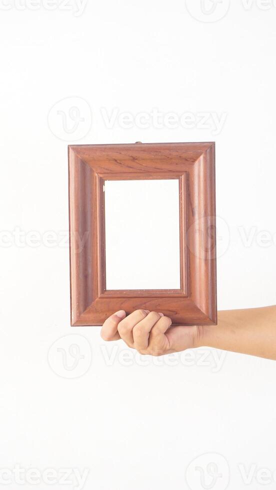 Hand holding brown wood photo frame isolated on white background