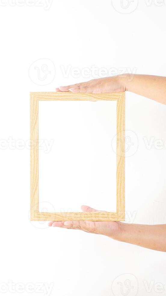 Hand holding thin wood picture frame isolated on white background photo