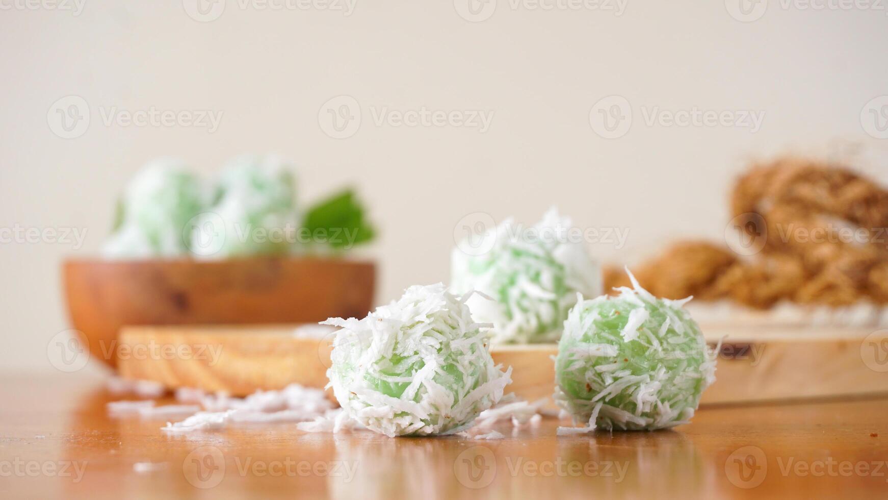 Klepon is a traditional Indonesian snack made from green sticky rice balls and rolled in grated coconut isolated on white background photo
