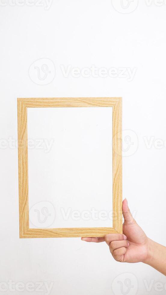 Hand holding wood photo frame isolated on white background