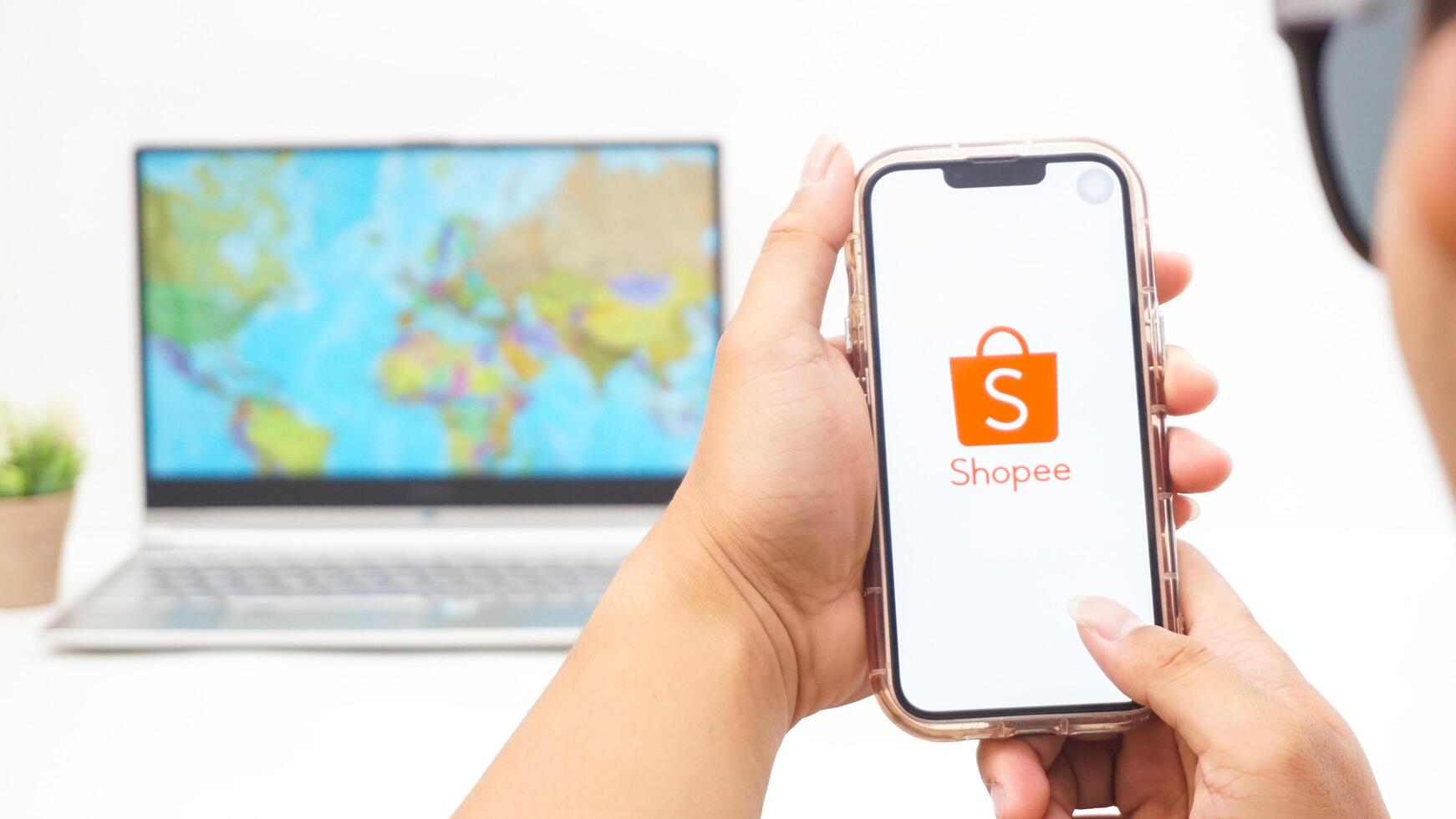 Yogyakarta, Indonesia, 2025 - Man holds smartphone with Shopee, electronic commerce or online shopping platform application is loaded on the screen isolated on white background photo