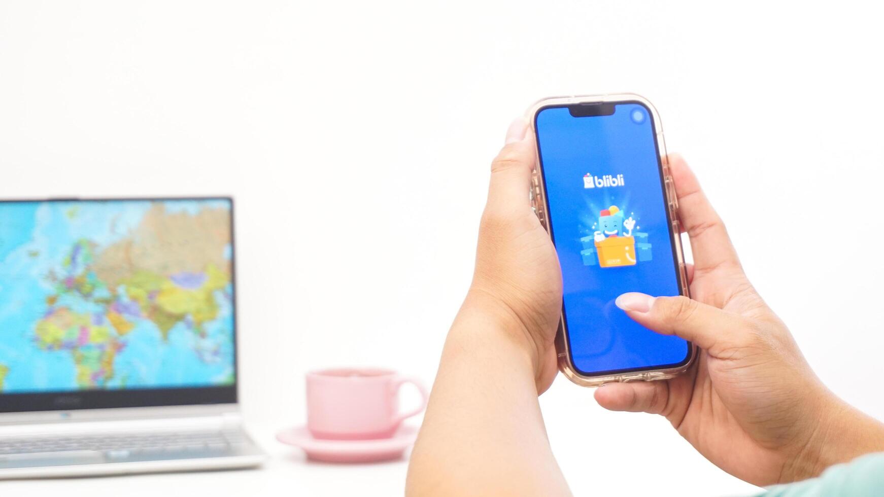 Yogyakarta, Indonesia, 2025 - Man holding smartphone showing Blibli, electronic commerce platform in Indonesia application on the screen isolated on white background photo