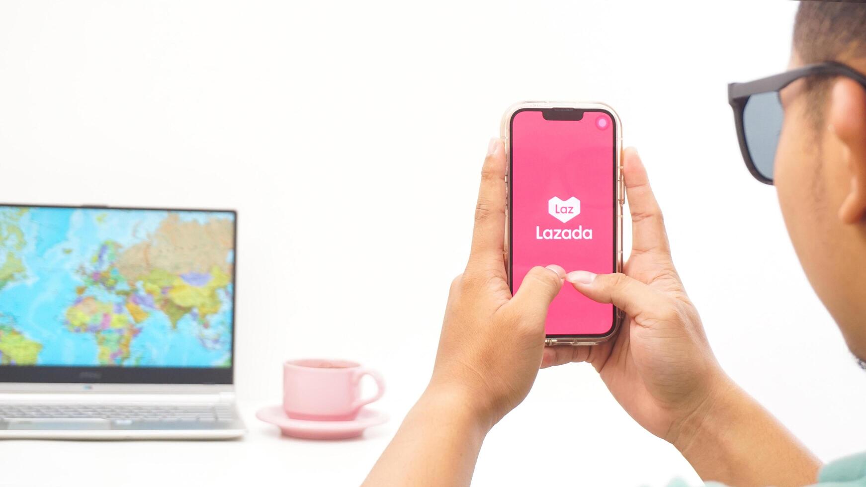 Yogyakarta, Indonesia, 2025 - Man holds smartphone with Lazada, electronic commerce platform application is loaded on the screen isolated on white background photo