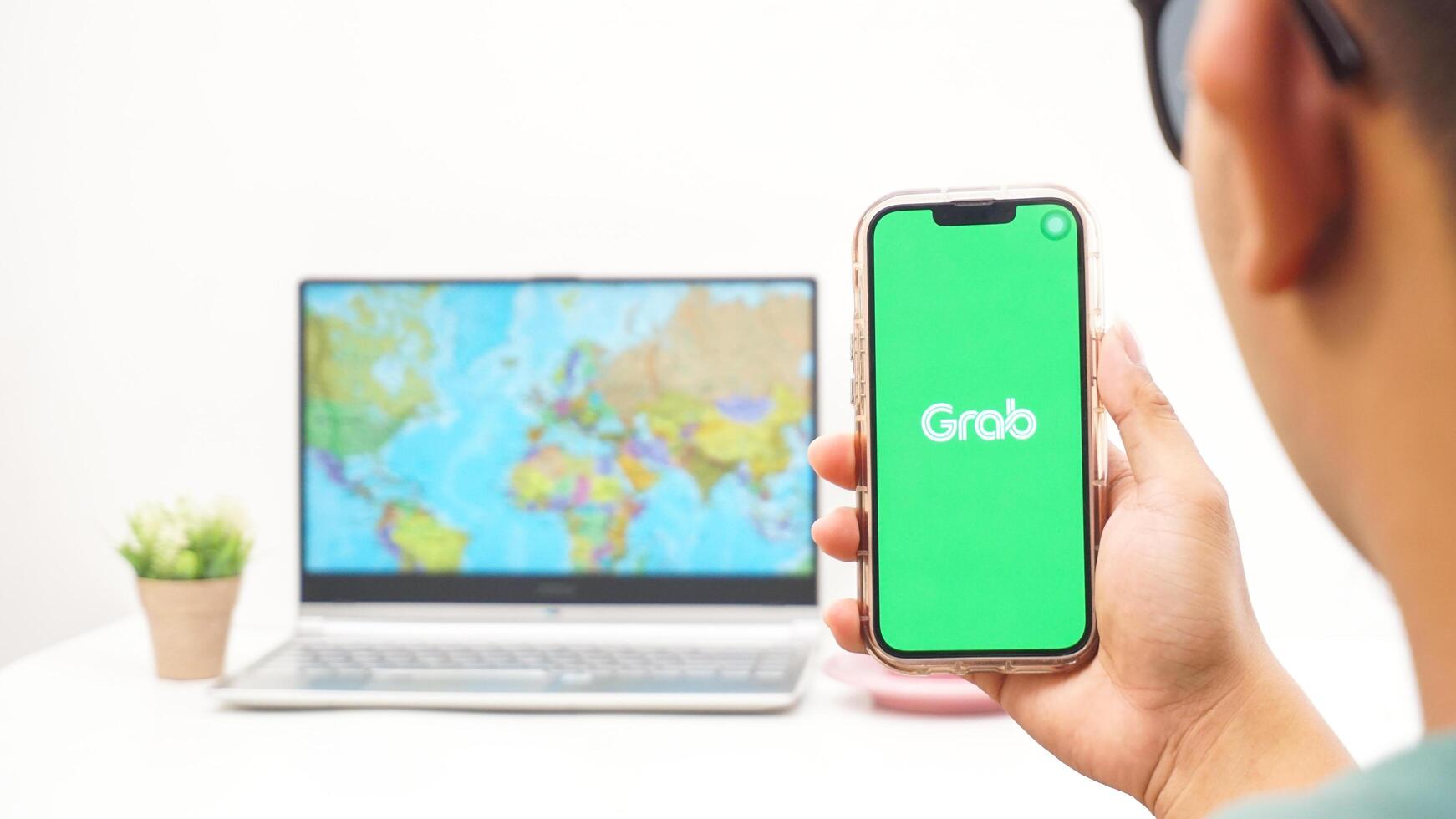 Yogyakarta, Indonesia, 2025 - Man holding smartphone showing Grab, on-demand service platforms in Indonesia application on the screen isolated on white background photo