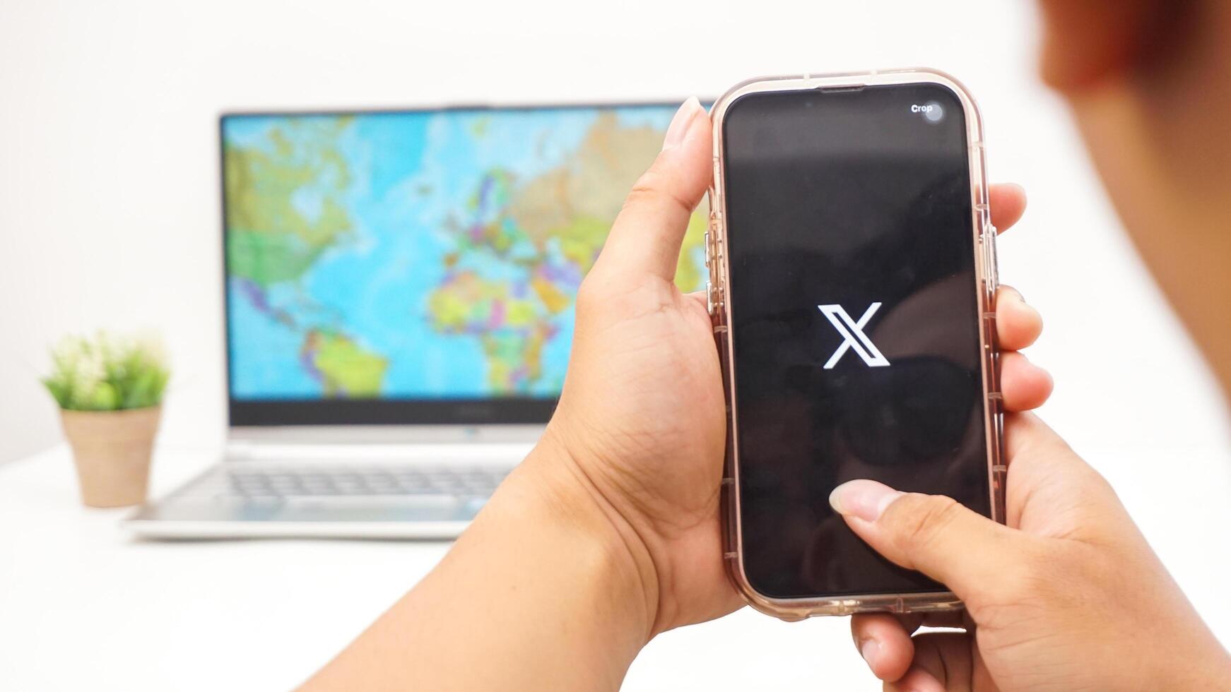 Yogyakarta, Indonesia, 2025 - Man holds smartphone with X former Twitter social media platform application on the screen isolated on white background photo