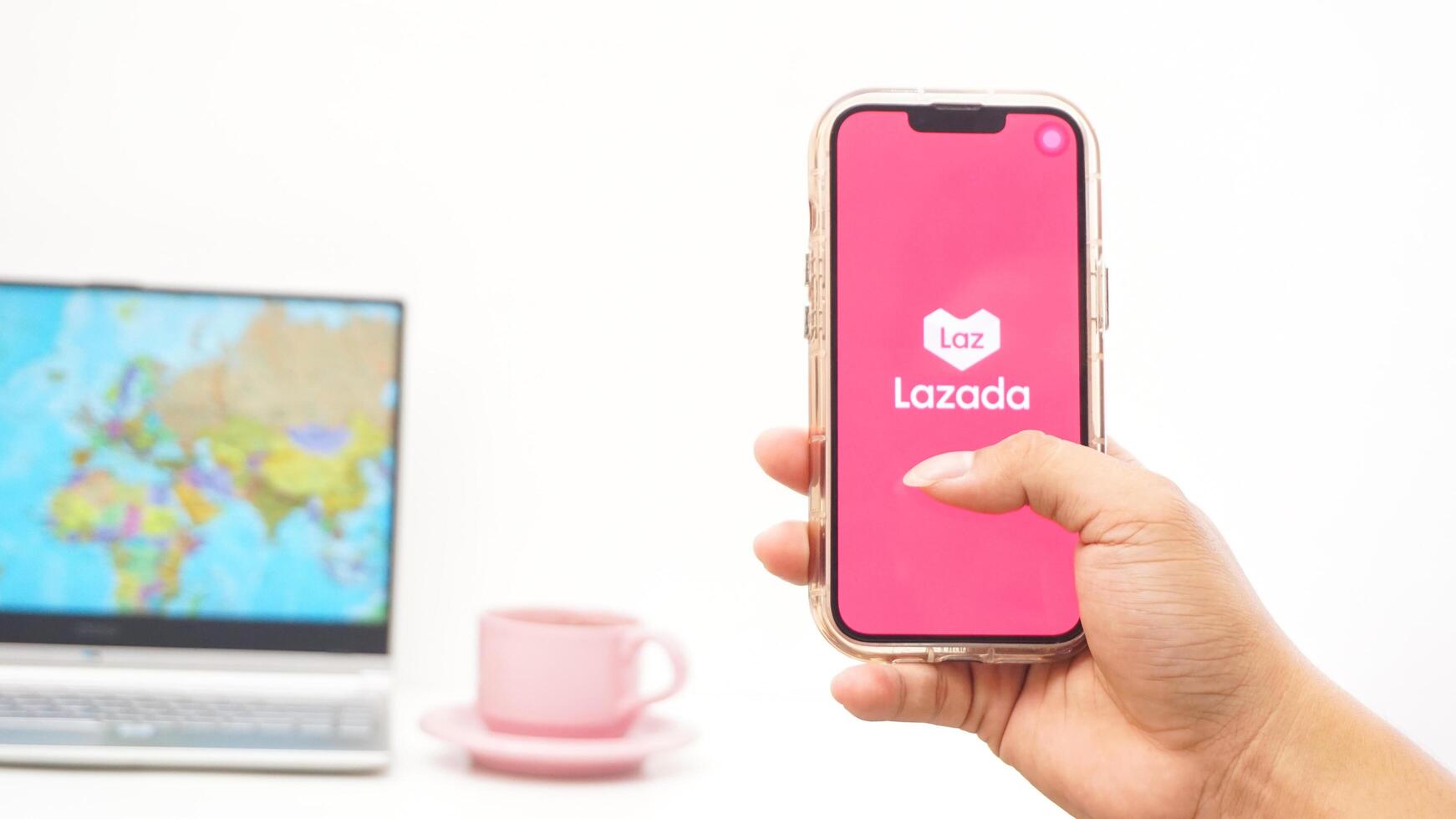 Yogyakarta, Indonesia, 2025 - Man holds smartphone with Lazada, electronic commerce platform application on the screen isolated on white background photo