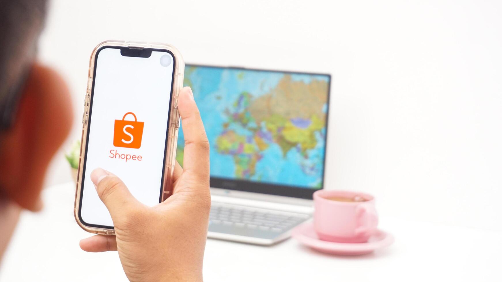 Yogyakarta, Indonesia, 2025 - Man open Shopee, electronic commerce or online shopping platform application on the smartphone isolated on white background photo