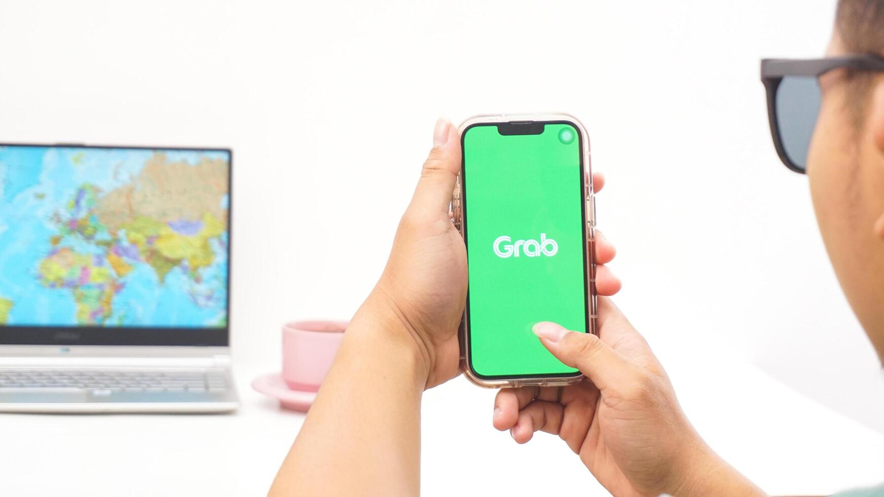 Yogyakarta, Indonesia, 2025 - Man holds smartphone with Grab, on-demand service platforms in Indonesia application is loaded on the screen isolated on white background photo