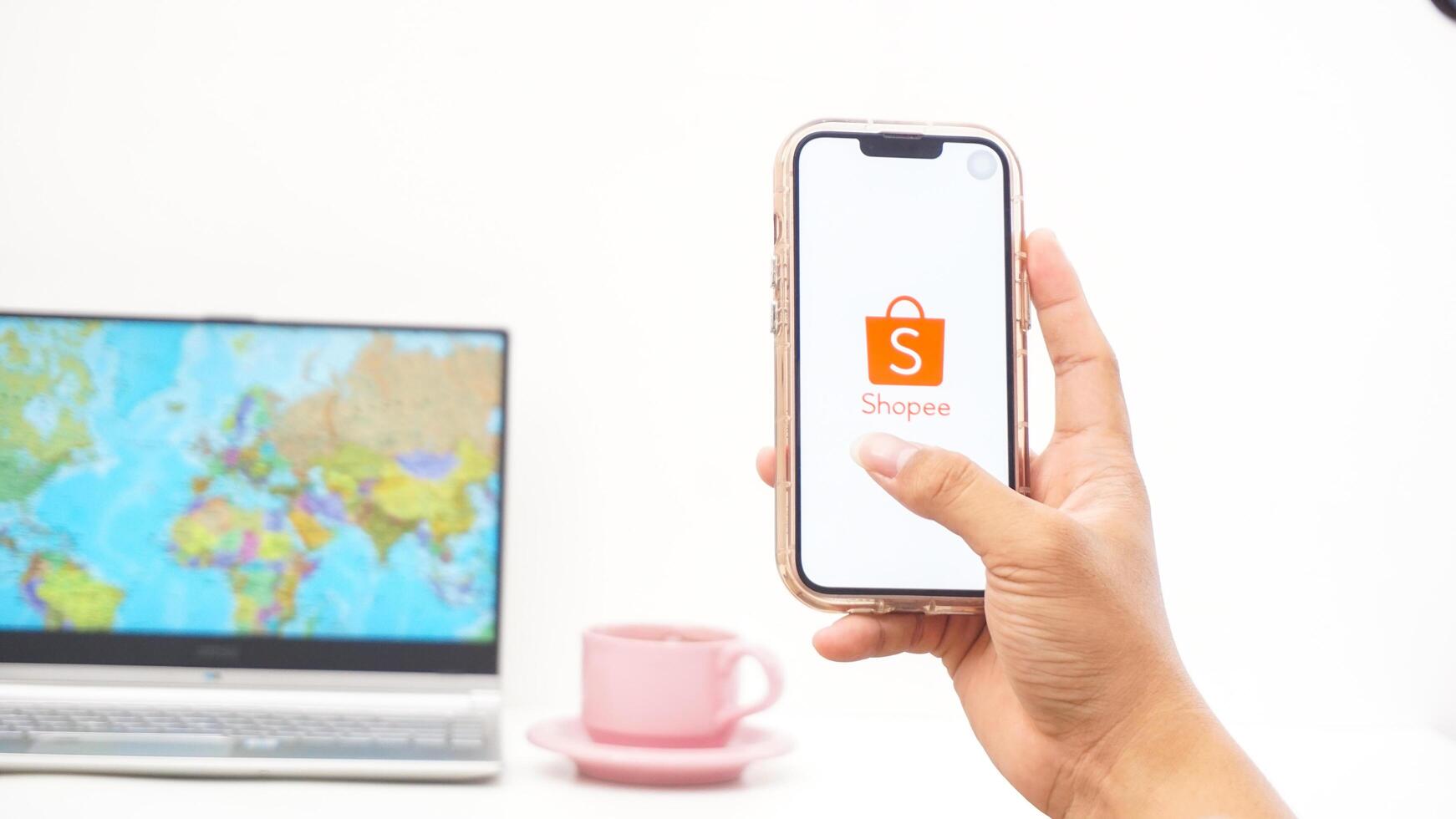 Yogyakarta, Indonesia, 2025 - Man holding smartphone with Shopee, electronic commerce or online shopping platform application on the screen isolated on white background photo