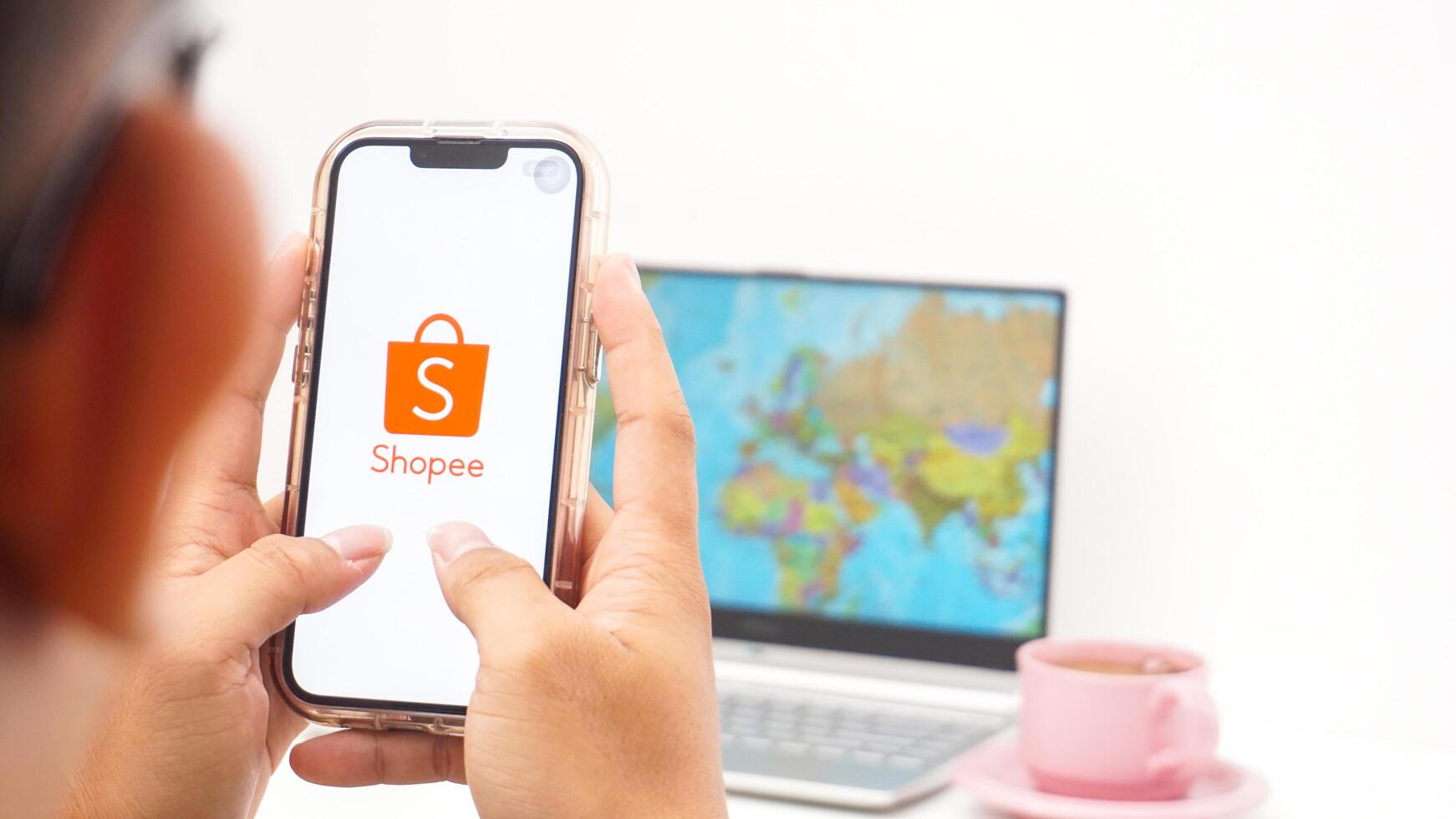 Yogyakarta, Indonesia, 2025 - Man holds smartphone showing Shopee, electronic commerce or online shopping platform application on the screen isolated on white background photo