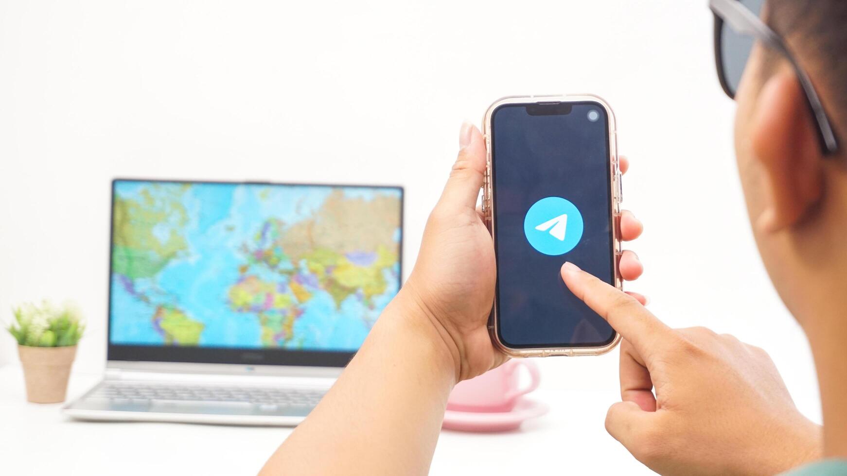 Yogyakarta, Indonesia, 2025 - Man holds smartphone showing Telegram, messaging and communication platform application on the screen isolated on white background photo